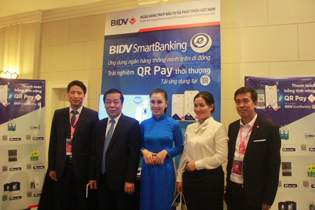 Phó Thống đốc NHNN Nguyễn Kim Anh thăm gian triển lãm,  trải nghiệm dịch vụ QR Pay và chụp ảnh lưu niệm với đại diện BIDV