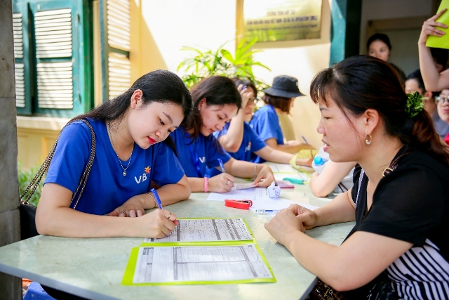 Các tình nguyện viên VIB đang hỗ trợ các gia đình bệnh nhân đăng ký khám