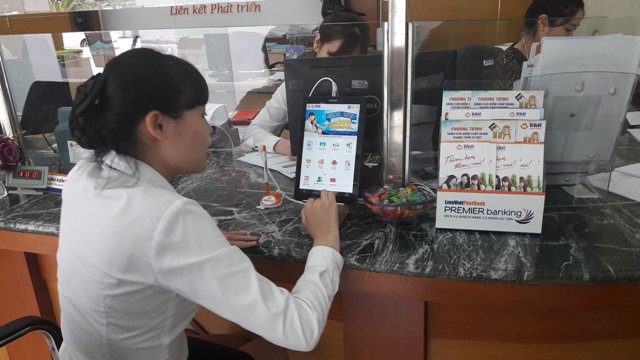 Cán bộ nhân viên LienVietPostBank đang thực hành sử dụng máy tính bảng để giới thiệu cho khách hàng