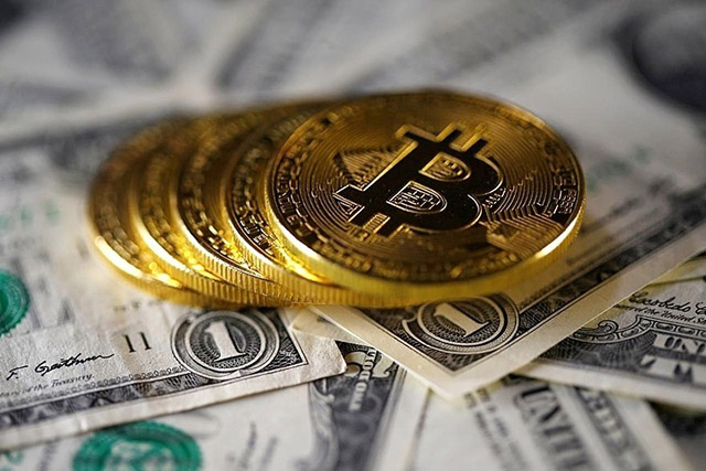 Đồng tiền mô phỏng Bitcoin và đồng đôla Mỹ. Ảnh: Reuters