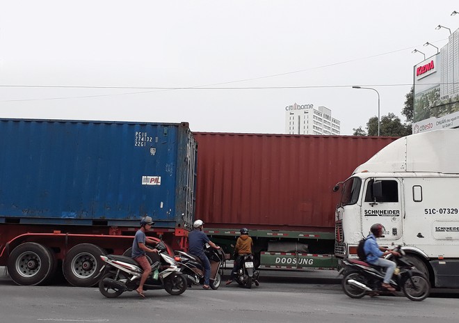 Người dân tại khu vực Cát Lái phải len lỏi qua những trước xe container để về nhà. Ảnh: Việt Dũng