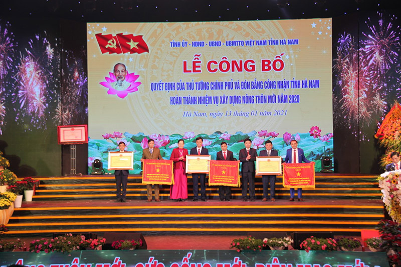 Bí thư Tỉnh ủy Hà Nam Lê Thị Thủy và chủ tịch UBND tỉnh Trương Quốc Huy trao Cờ và Bằng khen cho xã đạt chuẩn nông mới kiểu mẫu