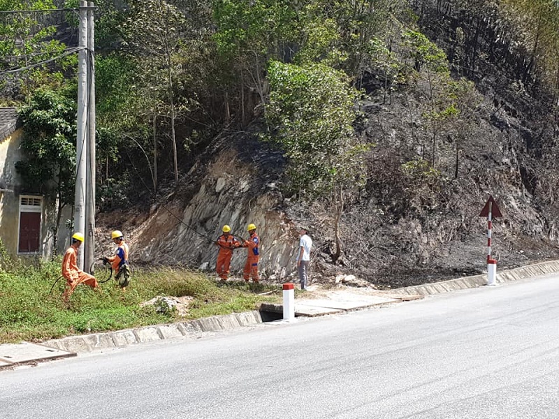 Nhân viên Điện lực Hương Sơn phối hợp với lực lượng chức năng phun nước khu vực xung quanh các cột điện gần bìa rừng để bảo vệ lưới điện