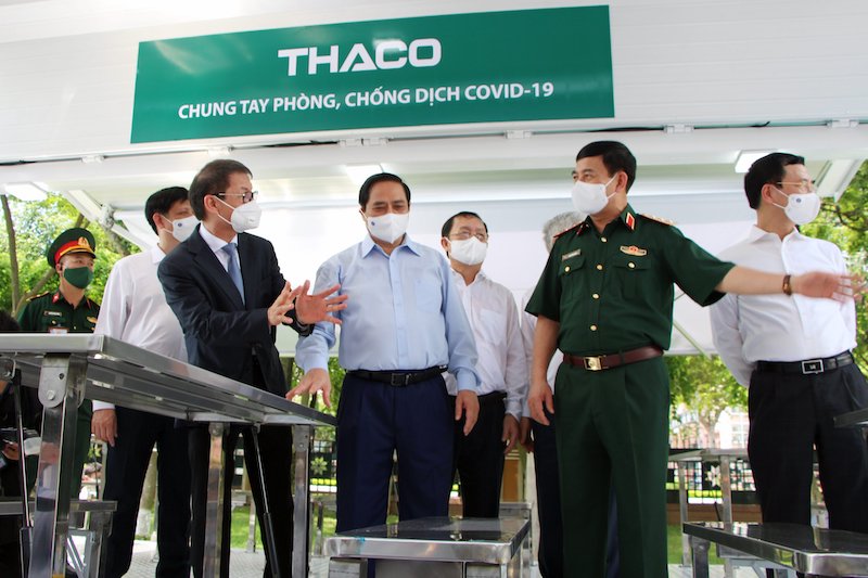 Thủ tướng Phạm Minh chính nghe ông Trần Bá Dương, Chủ tịch HĐQT THACO giới thiệu về công năng của xe phục vụ chiến dịch tiêm chủng 