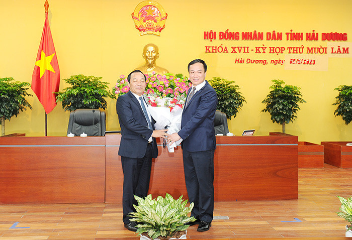 Ông Triệu Thế Hùng, Chủ tịch UBND tỉnh Hải Dương tặng hoa chúc mừng tân Chủ tịch HĐND tỉnh Lê Văn Hiệu. Ảnh: Thành Chung