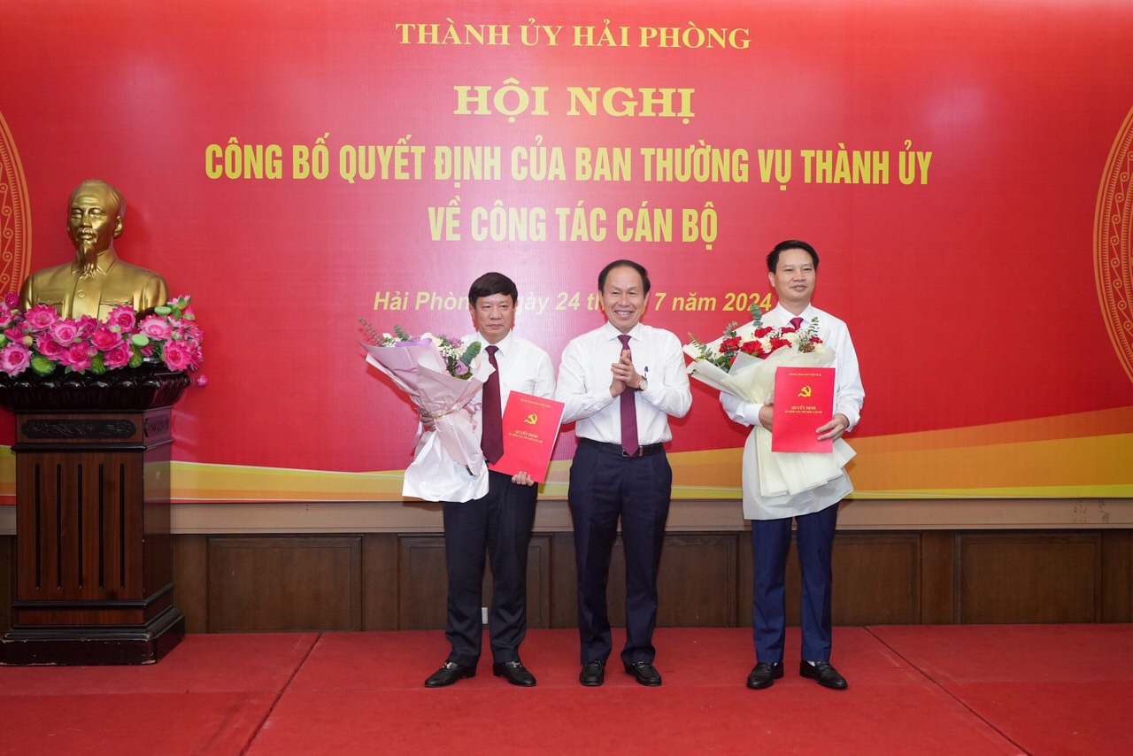 Ông Lê Tiến Châu, Bí thư Thành uỷ Hải Phòng trao Quyết định và tặng hoa chúc mừng ông Nguyễn Văn Tuấn (phải), tân Chánh văn phòng Thành ủy Hải Phòng và ông Phạm Quang Hiển (trái), tân Bí thư Đảng ủy Khối các cơ quan Thành phố