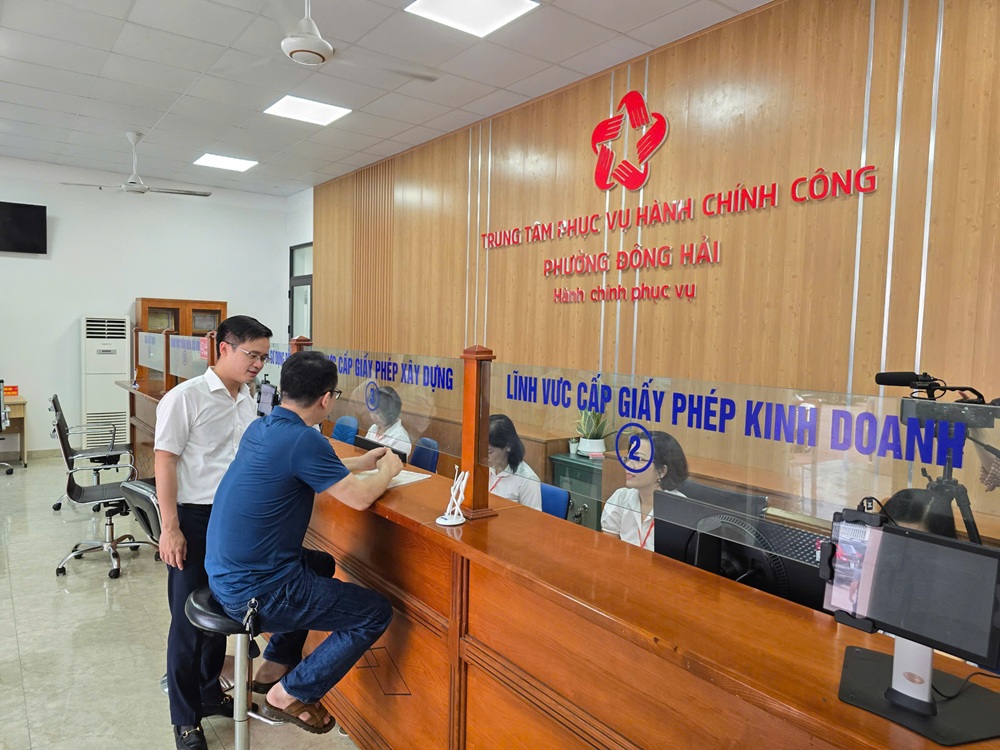 Ông Nguyễn Anh Tuấn, Chủ tịch UBND quận Hải An nói chuyện với công dân đầu tiên đến làm thủ tục hành chính tại Trung tâm phục vụ hành chính công phường Đông Hải (mới) trong ngày đầu thử nghiệm vận hành