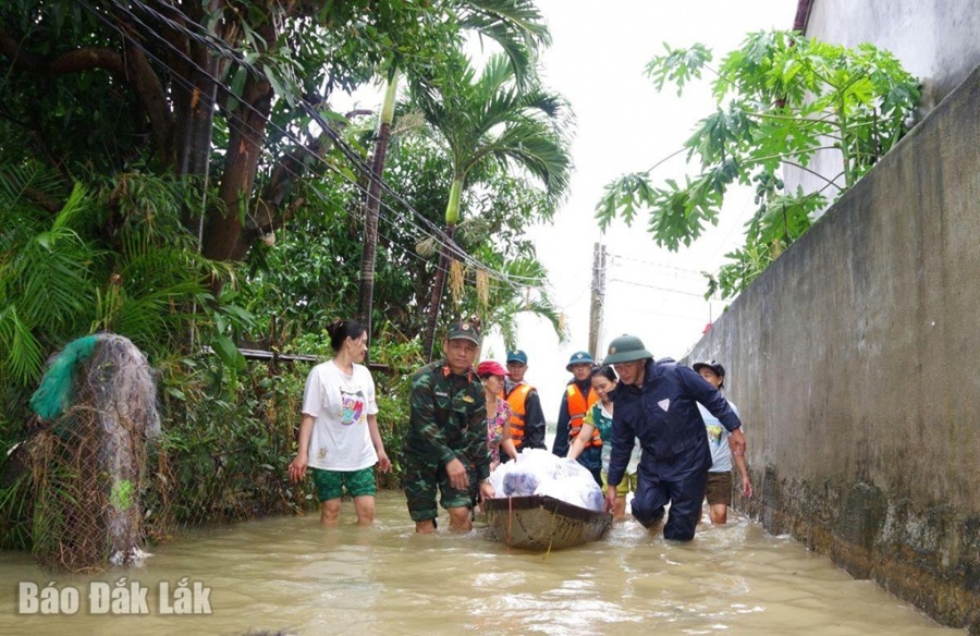 Bộ đội dùng xuồng mang thức ăn, nhu yếu phẩm cho người neo đơn, già yếu. Ảnh: Báo Đắk Lắk