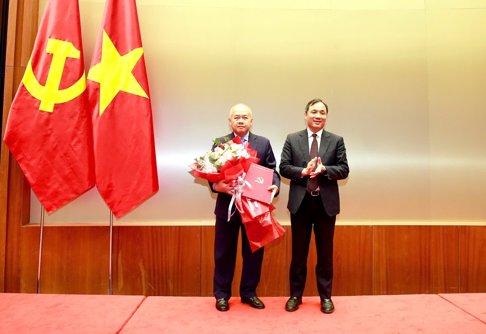 Ông Hoàng Trung Dũng, Phó Trưởng Ban Thường trực Ban Tổ chức Trung ương trao Quyết định và tặng hoa chúc mừng ông Đỗ Thành Trung