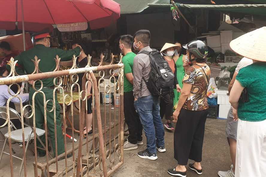 Một tổ công tác đặt tại một trong những lối vào chợ Hạ Long I, thành phố Hạ Long đang tiến hành đo thân nhiệt ngườii vào chợ.