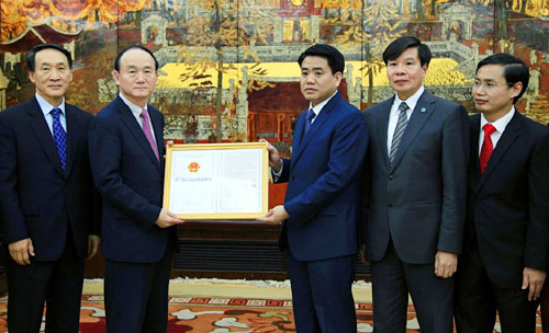 Chủ tịch UBND TP Nguyễn Đức Chung trao giấy chứng nhận đăng ký đầu tư cho Tổng giám đốc Tổ hợp Samsung Việt Nam