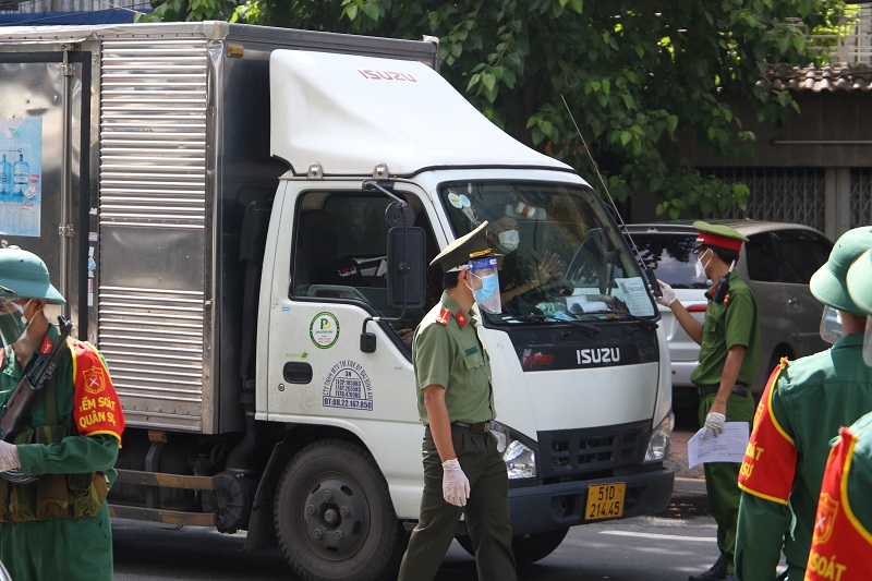 Lực lượng chức năng tại chốt kiểm soát kiểm tra giấy tờ lưu thông của tài xế vận chuyển