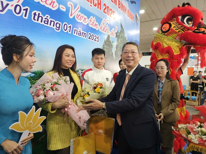 Ông Trần Văn Thanh, Giám đốc Sở Du lịch tỉnh Bình Định tặng hoa và quà cho những du khách may mắn.