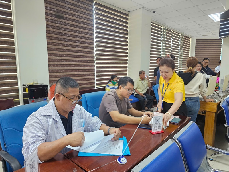 Nhân viên Bưu điện tỉnh Gia Lai hỗ trợ người dân làm thủ tục hành chính.