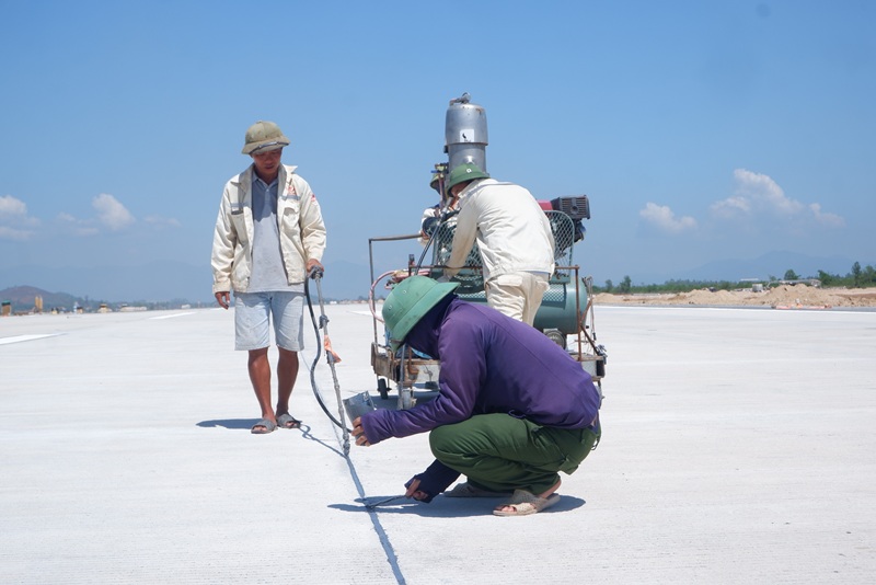 C&ocirc;ng nh&acirc;n tr&eacute;t dầu bịt c&aacute;c khe giản nỡ b&ecirc; t&ocirc;ng.