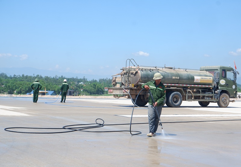 C&ocirc;ng nh&acirc;n xịt nước vệ sinh c&aacute;c khe giản nỡ b&ecirc; t&ocirc;ng tr&ecirc;n đường cất hạ c&aacute;nh.
