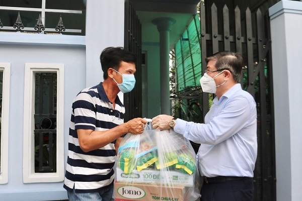 Chủ tịch UBND TP.HCM Nguyễn Thành Phong (bên phải) tặng quà cho người dân nghèo ở huyện Nhà Bè