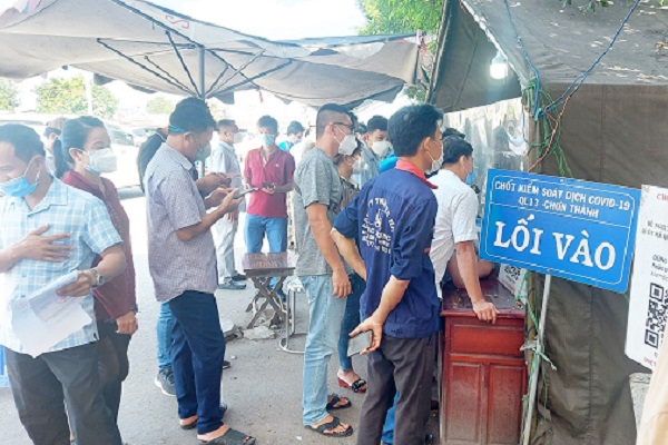 Người dân đợi làm thủ tục tại Chốt kiểm soát dịch Covid-19 Quốc lộ 13, huyện Chơn Thành, tỉnh Bình Phước.