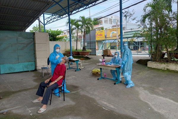 Nhân viên y tế lấy mẫu xét nghiệm Covid-19 cho người dân tại Trạm y tế lưu động xã Phong Phú, huyện Bình Chánh, TP Hồ Chí Minh 