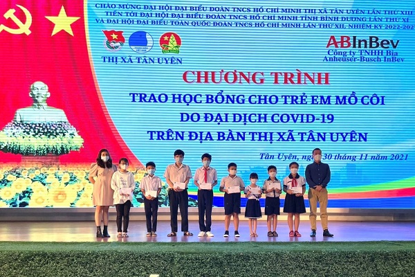 Đại diện Công ty TNHH Bia Anheuser-Busch InBev trao học bổng cho các trẻ em mồ côi tại thị xã Tân Uyên, tỉnh Bình Dương