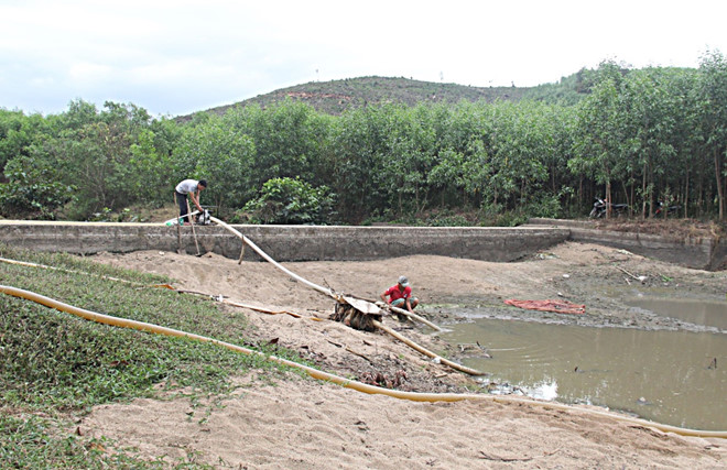 Người dân H.Khánh Vĩnh (Khánh Hòa) lấy nước tưới từ lòng hồ đang cạn dần vì nắng hạn