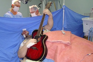 Người đàn ông chơi đàn guitar khi đang cắt u não