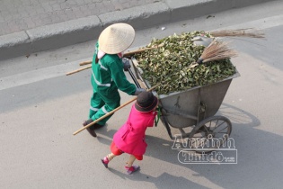 Xúc động hình ảnh em bé đi quét rác cùng mẹ trong ngày Tết 