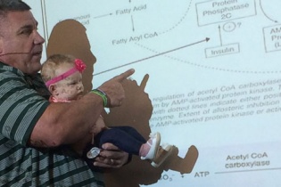 Thầy giáo vừa bế con hộ sinh viên vừa giảng bài