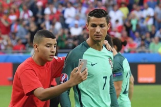 Cậu bé nhặt bóng vào sân ôm, nắm tay và chụp ảnh với C. Ronaldo