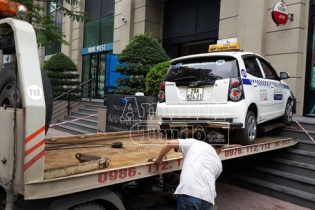 Xe taxi phi lên bậc tam cấp tòa nhà kéo theo cụ già