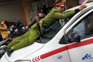 Tài xế taxi hất cảnh sát lên nóc ca-pô bị tạm giữ hình sự